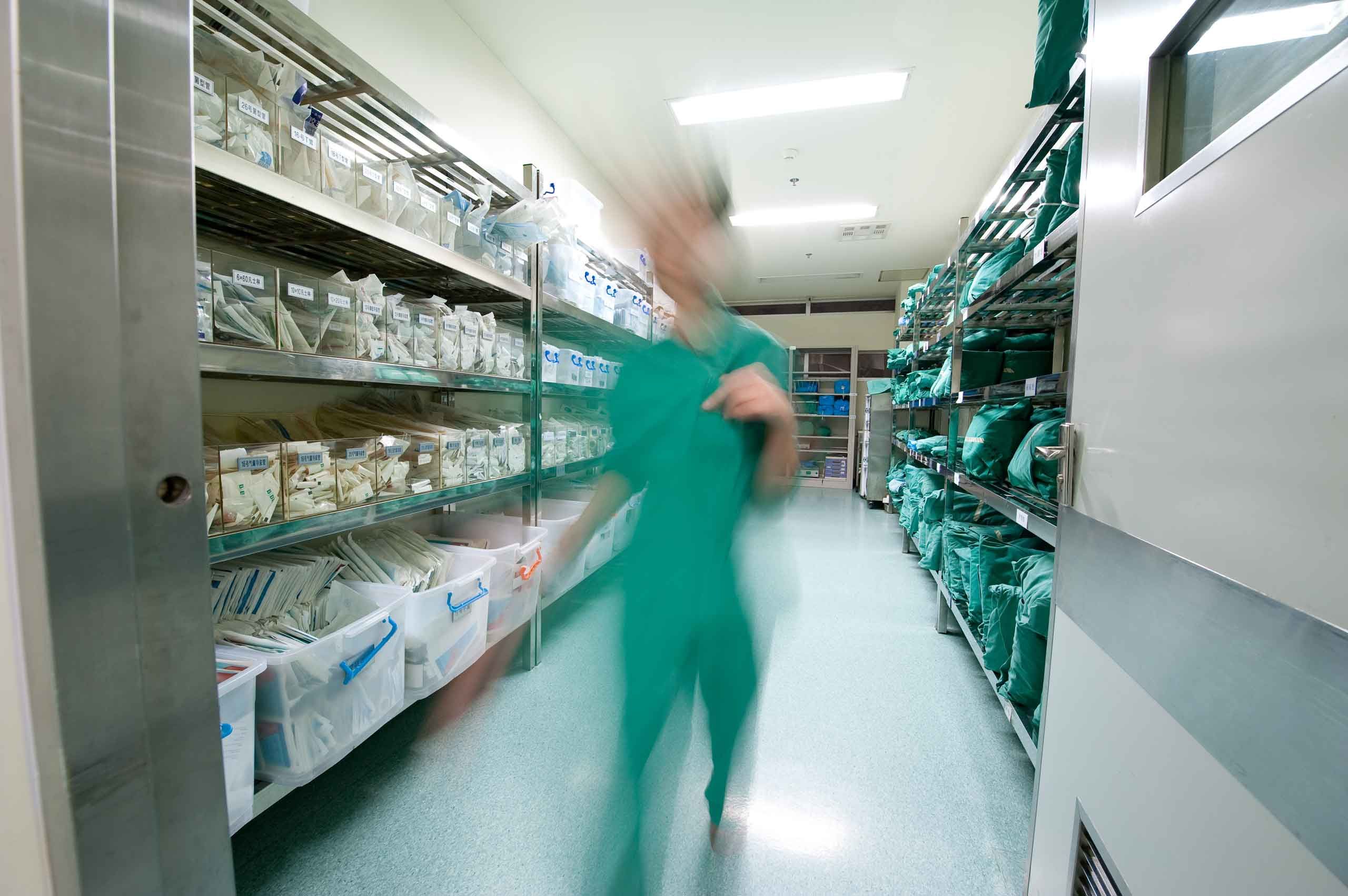 A nurse in hospital warehouse, a warehouse full of medical devices image.