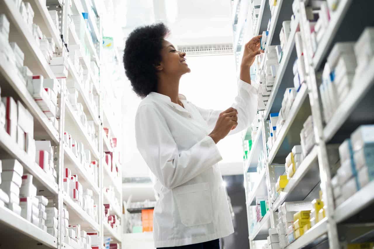 Image of pharmacist selecting a prescription drug from the stock.