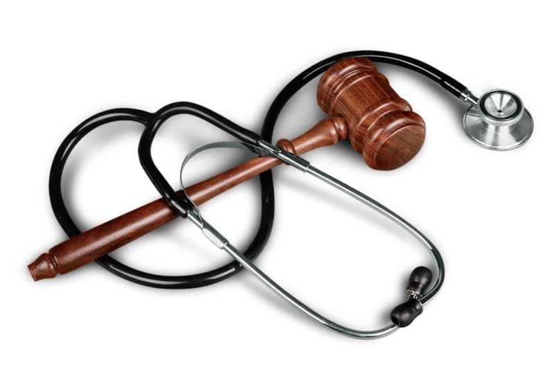 Healthcare And Medicine Law Legal System Medicine Moral Dilemma Government Justice image of stethoscope wrapped up with a judges gavel.